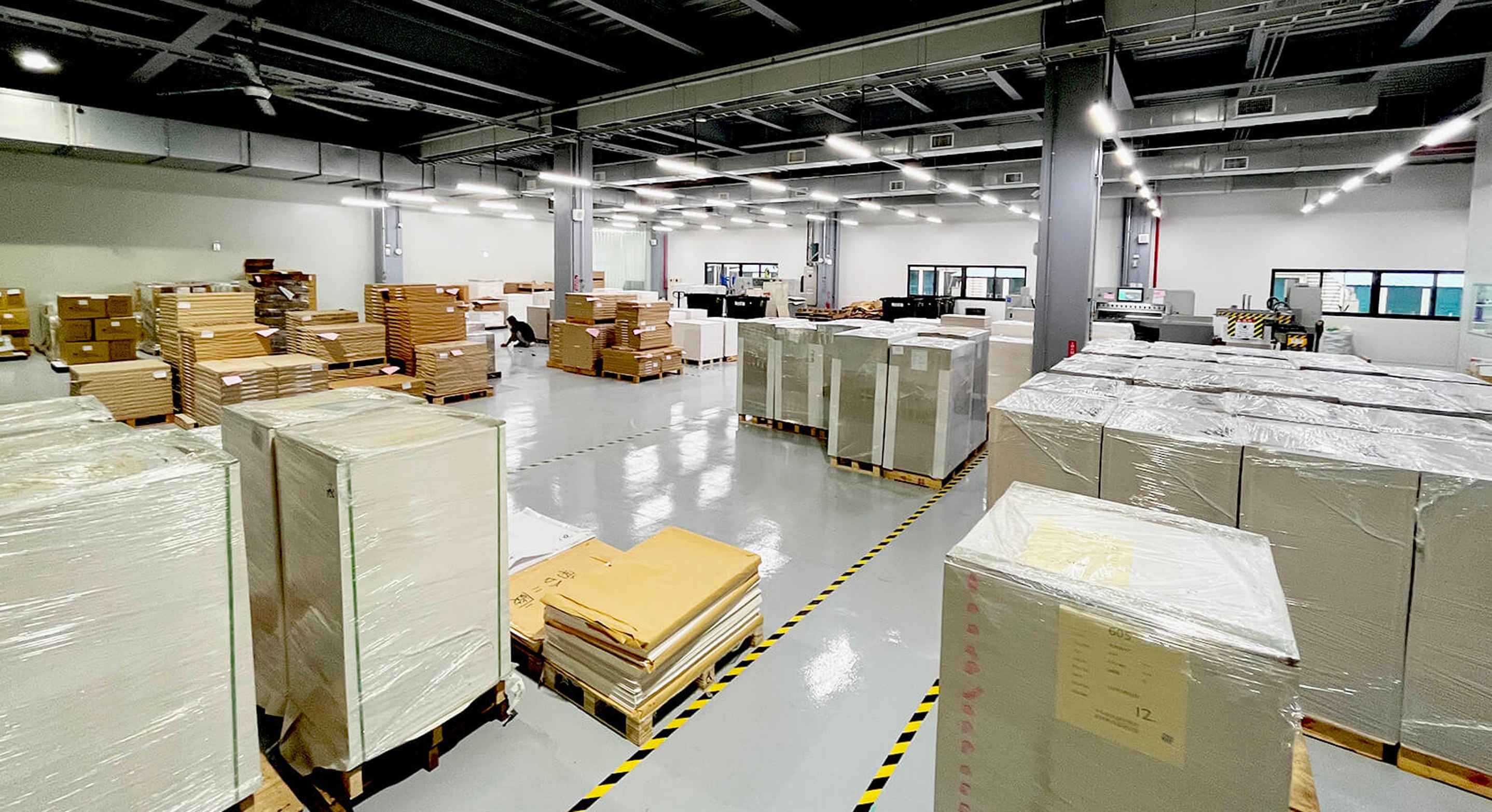 Inside the NTI factory floor — palletised packaging stock and clean production aisles